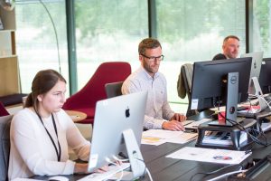 Group of people seated at desks collaborating together on a project
